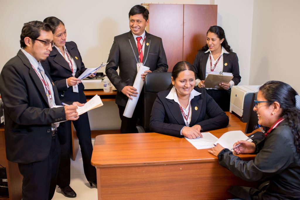 Foto del personal administrativo reunido en oficina.