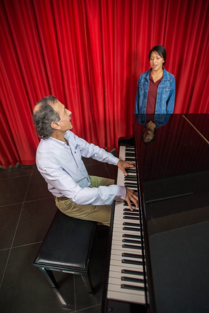 Foto de docente y estudiante mujer en clase práctica de piano